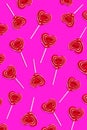 Red heart lollipops pattern on purple background