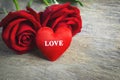 Red heart with love text and red rose flowers on wooden background, Valentine roses Royalty Free Stock Photo