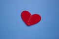 Red heart made of cloth with white thread on a blue background the Concept of Sadness, unrequited love, a broken heart Royalty Free Stock Photo