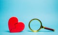 Red heart and a magnifying glass. The concept of finding love and relationships. Find a soul mate. Loneliness. Family psychologist