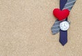 Red heart on men deisgn necktie with vintage watch on brown texture backgrond