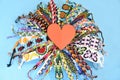 Red heart in the middle of circle of many multi-colored woven DIY friendship bracelets handmade of embroidery bright thread with k