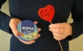 Red heart and nivea cream in the female hands