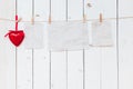 Red heart and old paper blank hanging at clothesline on wood white background with space. Valentine Day. Royalty Free Stock Photo