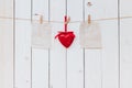 Red heart and old paper blank hanging at clothesline on wood white background with space. Valentine Day. Royalty Free Stock Photo