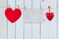 Red heart and old paper blank hanging at clothesline on wood white background with space. Valentine Day. Royalty Free Stock Photo