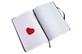 Red heart on the open pages of a notebook or journal.