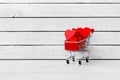 Red Heart Paper Shaped in trolley shopping cart over white wood background Royalty Free Stock Photo