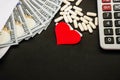 Red heart, pills, dollars in an envelope on a black background. Health concept.