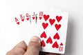 Red heart playing cards straight flush in hand