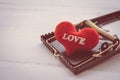 Red heart in a rat trap on white wooden background. Online internet romance scam or valentine day in darkside concept.