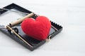 Red heart in a rat trap on white wooden background. Online internet romance scam or valentine day in darkside concept. Royalty Free Stock Photo