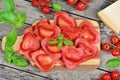 Red heart ravioli with tomato, mozzarella and basil on a wood background Royalty Free Stock Photo