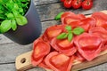 Red heart ravioli with tomato, mozzarella and basil on a wood background Royalty Free Stock Photo