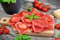 Red heart ravioli with tomato, mozzarella and basil on a wood background Royalty Free Stock Photo