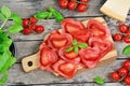 Red heart ravioli with tomato, mozzarella and basil on a wood background Royalty Free Stock Photo