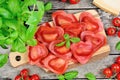 Red heart ravioli with tomato, mozzarella and basil on a wood background Royalty Free Stock Photo