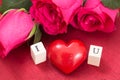 Red heart and roses, and wooden cubes with letters I and U.