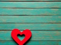 A red heart with a second heart carved inside lies on a wooden surface made of narrow horizontal planks painted Royalty Free Stock Photo