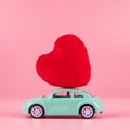 Red heart shape decoration on mini car toy with copy space for text on pink background. Love, Wedding, Romantic and Happy Royalty Free Stock Photo