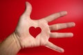 Red heart shape drawed on a male human hand