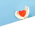 Red heart shape hold female hands in sterile gloves. Blue background.Copy space for text. Mock up