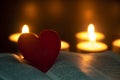 Red heart shape on Holy Bible with candle lights background. Customizable space for text or ideas. Royalty Free Stock Photo