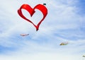 Red heart shape kite is flying in blue sky Royalty Free Stock Photo