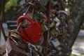 The red heart shape padlock hanging in the middle of many blurred padlocks. Valentine's day. Locks on the bridge. Royalty Free Stock Photo