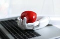 Red heart shape in robot hand on laptop keyboard, AI Royalty Free Stock Photo