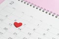 Red heart shape on 14th February calendar on pink background using as romantic Valentines day concept