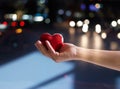 Red heart shape in woman hand on street at night, Valentine's day Royalty Free Stock Photo