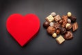 Red heart shaped box with chocolate pralines on dark background Royalty Free Stock Photo