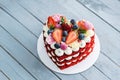 Red heart shaped cake decorated with white whipped cream slices of fresh strawberries . Concept of Valentine`s day Royalty Free Stock Photo