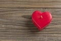 Red heart shaped candle on a wooden surface Royalty Free Stock Photo