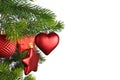 Red heart shaped Christmas bauble on decorated Christmas tree on side of white background Royalty Free Stock Photo