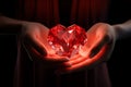 A red heart-shaped crystal in a woman& x27;s hands. Luxurious red decoration for Valentine& x27;s Day Royalty Free Stock Photo