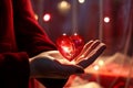 A red heart-shaped crystal in a womans hands. Luxurious red decoration for Valentines Day Royalty Free Stock Photo