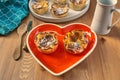 Red heart-shaped dish with pastries for Valentine`s Day.