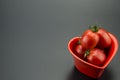 Red heart-shaped dish and small tomatoes Royalty Free Stock Photo