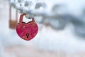 Red heart-shaped hanging from bridge chain, symbol of love, copy space