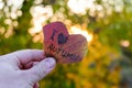 Red heart shaped leaf in a hand on bright autumn foliage bokeh background Royalty Free Stock Photo