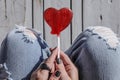 Red heart shaped lollipop in a trendy fashionable woman`s hands, top view. Royalty Free Stock Photo