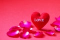 A red heart shaped with Love and Rose petals on red background Royalty Free Stock Photo