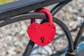 Red heart-shaped pendant lock hanging from the fence as a symbol of marriage Royalty Free Stock Photo