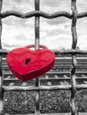 Red heart-shaped rusty padlock chained to a railing at the monochrome background Royalty Free Stock Photo