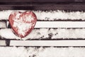 Red heart shaped tin box on a bench Royalty Free Stock Photo