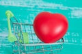 Red heart sign in shopping cart on wood Royalty Free Stock Photo