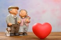 red heart and smiling elder couple on background