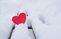 Red heart on a snow-covered bench in the park in valentines day in winter Royalty Free Stock Photo
